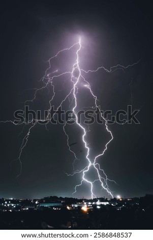 A dramatic photograph capturing powerful lightning strikes illuminating the dark sky. The jagged bolts of electricity contrast against the storm clouds, creating a breathtaking natural spectacle.