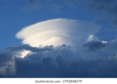 Dramatic pileus cloud forming on top of a rapidly developing convective storm cloud