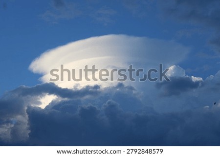 Dramatic pileus cloud forming on top of a rapidly developing convective storm cloud