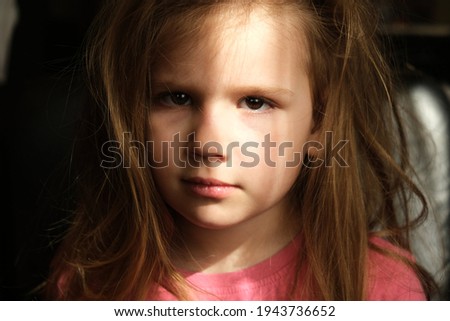 Dramatic portrait of beautiful sad little child girl with shadow on face. lonely in dark. Childhood and problems of parents and children concept. unknown and extraordinary child's soul and inner world