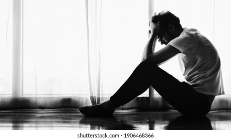 dramatic portrait of caucasian man sitting alone by window at home looking sorrow with desperate feeing and depressed from unemployment in black and white - Powered by Shutterstock