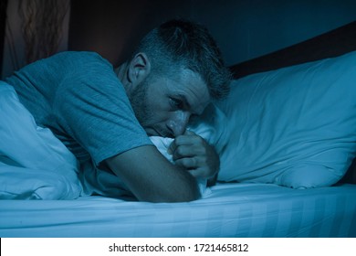 dramatic portrait in the dark of attractive depressed and worried man on bed suffering depression crisis and anxiety feeling lost lying sleepless in insomnia and life problem concept - Shutterstock ID 1721465812
