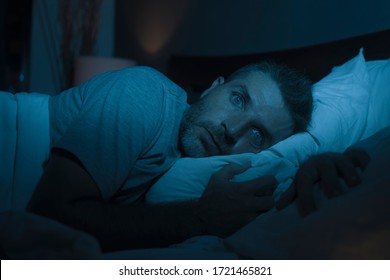 dramatic portrait in the dark of attractive depressed and worried man on bed suffering depression crisis and anxiety feeling lost lying sleepless in insomnia and life problem concept - Shutterstock ID 1721465821