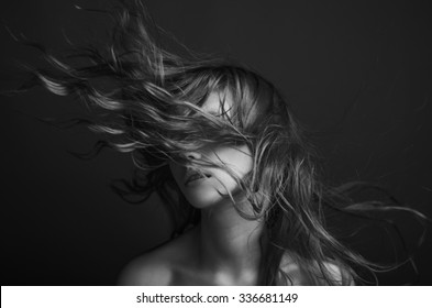 Dramatic Portrait Of A Girl Theme: Portrait Of A Beautiful Girl With Flying Hair In The Wind Against A Background, Black And White Photography