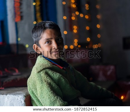 Dramatic portrait of an indian young kid in lowkey with bokeh lights