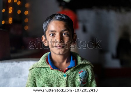 Dramatic portrait of an indian young kid in lowkey with bokeh lights
