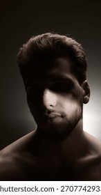 Dramatic portrait of man with post-procedure nose bandage in focused side lighting. Concept of cosmetic recovery, emotional introspection, aesthetic surgery storytelling, and male beauty narratives.