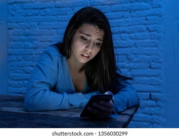 Dramatic Portrait Of Sad Scared Young Woman On Smart Mobile Phone Suffering Cyber Bullying And Harassment. Feeling Lonely, Depressed And In Fear Being Abused By Online Stalker. In Dangers Of Internet.