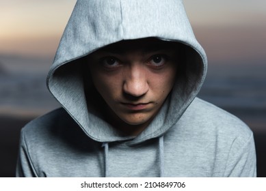 Dramatic Portrait Of Serious Hispanic Teenager Looking To The Camera And Wearing A Hoodie.