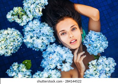 dramatic portrait of a woman floating an a swimming pool full of