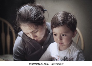 Dramatic Portrait Of A Young Asian Woman And Her Young Son Mourning The Death Of A Father