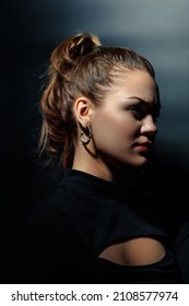 Dramatic Portrait Of Young Beautiful Girl In Profile On Dark Background. Vertical Studio Photo Of Caucasian Model. Strong Strong-willed And Bold Look. Daring Beauty.