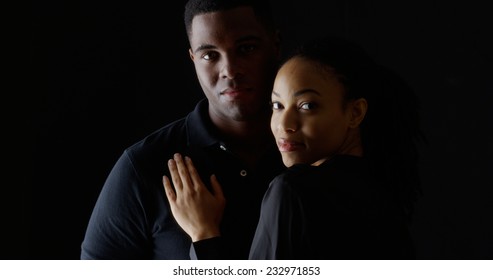 Dramatic portrait of young black woman holding boyfriend