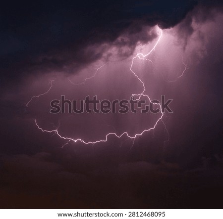 Dramatic purple lightning bolt in dark storm clouds, powerful thunderstorm at night, atmospheric weather phenomenon