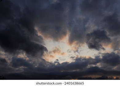 Dramatic purple-gray clouds are visible through the sunlight