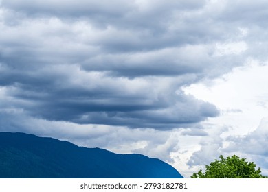 Dramatic Rainfall and Storm Clouds Over Forested Mountains in British Columbia, Canada