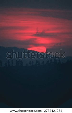 Dramatic Red and Blue Sunset Over Forested Valley Silhouettes