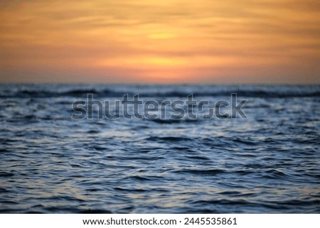 Dramatic red ocean waves at sunset with soft evening sea dark water