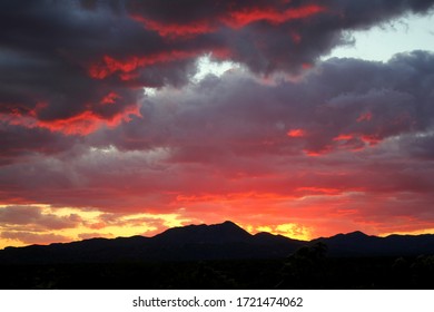 Dramatic Red, Orange, Purple And Pink Rolling Monsoon Clouds At Sunset Over The  Mountains In The Tucson, Arizona Desert.