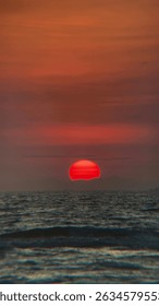 Dramatic red sunset sinking below the horizon over the ocean. Evokes feelings of mystery and the end of the day. Ideal for dramatic landscape visuals. #RedSunset #OceanSunset #DramaticSky