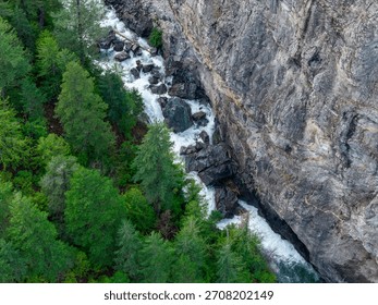 A dramatic river cuts through a rocky canyon edged by dense evergreen forest in BC, Canada