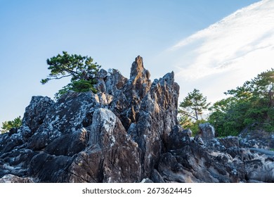 Dramatic Rock Formation with Pine Trees under Clear Blue Sky