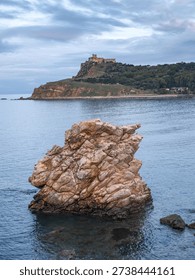 Dramatic rock formations along the Tabarka coastline. The unique geological structures meet a calm Mediterranean sea under a moody winter sky, creating a serene and atmospheric North African landscape.