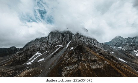 Dramatic Rocky Mountain Peak with Cloud Cover
A rugged mountain peak partially obscured by clouds, showing rocky terrain and patches of snow under a moody sky.
 - Powered by Shutterstock