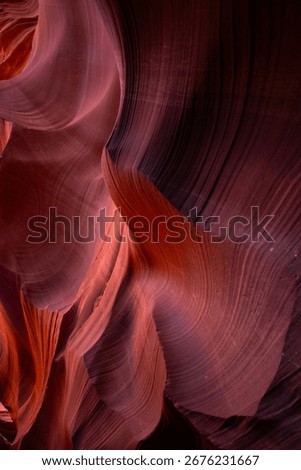 Dramatic sandstone formations inside Grand Canyon glow with rich red and orange tones, carved naturally by water and time, creating stunning abstract desert textures.