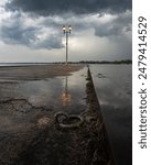 A dramatic scene of a boat docking anchor sitting in front of a puddle reflection on a pier in Orillia