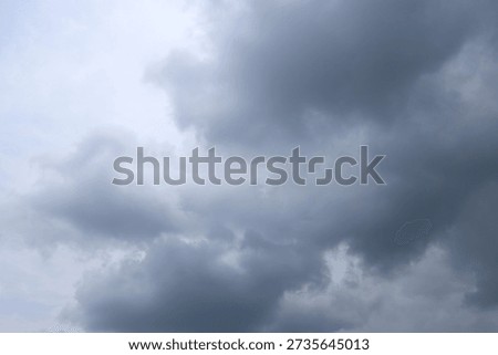 A dramatic scene featuring dark, heavy storm clouds filling the sky, creating a tense and ominous atmosphere indicative of impending weather changes.
