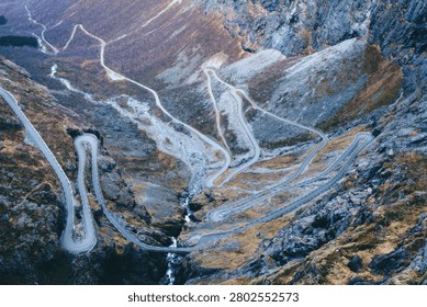 A dramatic scene of lightning striking over a rugged mountain terrain during night time, creating bright flashes and illuminating the rocks.