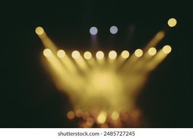 Dramatic scene of stage lighting with beams of light cutting through the darkness, creating an intense and mysterious atmosphere. The smoke or mist illuminated by the lights adds texture.
