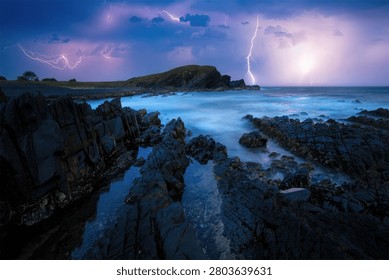 A dramatic scene of a stormy night with lightning over rocky coast and ocean