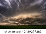 A dramatic scene of a stormy sky with lightning striking over a green field in Nebraska Plains, USA