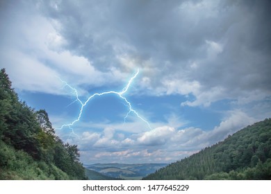 Dramatic scene of thunderstorm with lightning in dark stormy sky in mountains