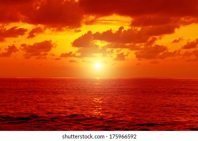Dramatic   sea with sun rays and clouds in golden orange  colors