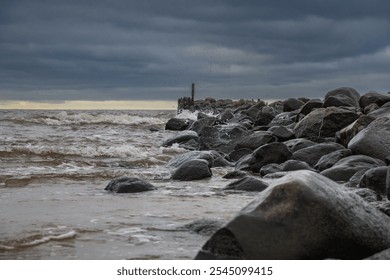 A dramatic seascape with crashing waves against a rocky breakwater, stretching towards the horizon. The stormy sky. - Powered by Shutterstock