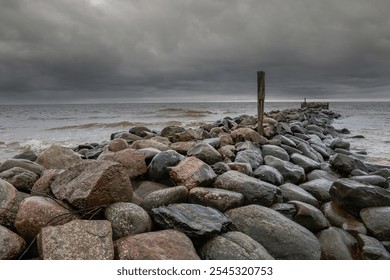 A dramatic seascape with crashing waves against a rocky breakwater, stretching towards the horizon. The stormy sky. - Powered by Shutterstock