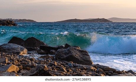 Dramatic seascape with powerful ocean wave crashing against rocky shore during sunset. Natural coastal landscape with dynamic water motion and textured stones, travel and nature concept.
