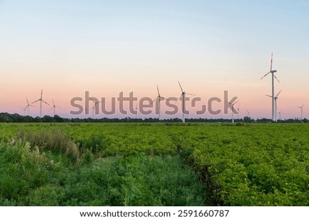 Dramatic sequence of a wind turbine collapsing on an open field, illuminated by the warm hues of a sunset.