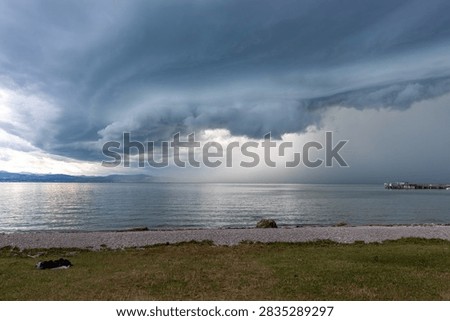Dramatic shelf cloud hovering over Lake Constance shoreline in Langenargen during approaching summer thunderstorm, Germany
