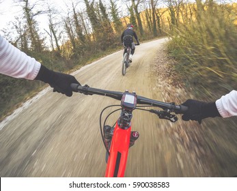 Dramatic Shot Of Pair Of Young Men Mountain Biking In A Forest. POV Original Point Of View