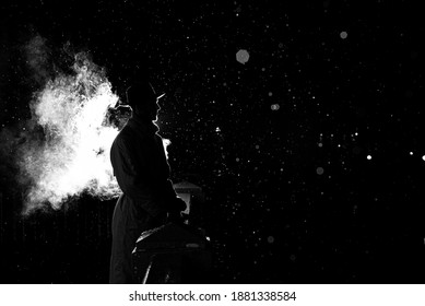 Dramatic Silhouette Of A Dangerous Man In A Hat At Night In The Rain In The City In The Old Crime Noir Style