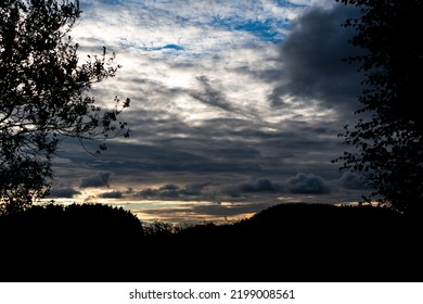 Dramatic sky before sunset framed by the silhouettes of trees