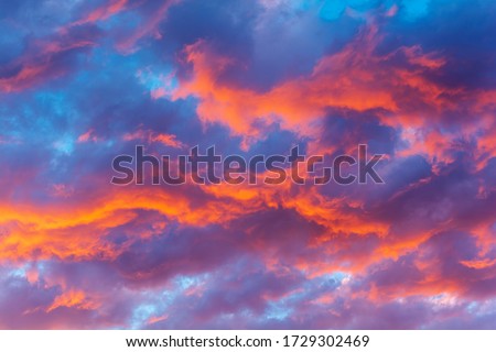 Dramatic sky with bright red and dark blue stormy clouds. Nature background