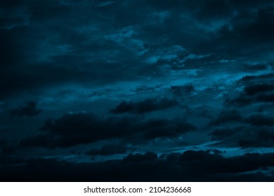  Dramatic sky with clouds. Black blue green night sky. Thunderstorm. Dark teal color background. Ominous,  frightening.                            
