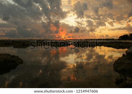 dramatic sky clouds. Sun beams or rays breaking through the dark dramatic clouds at sunset.