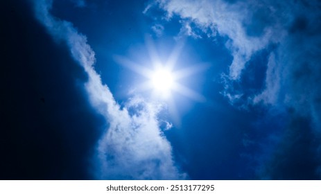 dramatic sky with dark clouds and a ray of sunlight breaking through. The clouds are a deep, stormy gray, and the sunlight is a bright, golden beam that cuts through the darkness