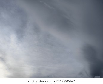 A dramatic sky with dark storm clouds gathering and lighter wispy clouds in contrast.